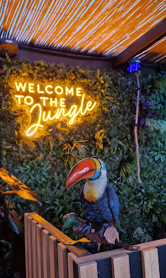 Neón 'Welcome to the Jungle' sobre pared vegetal con el tucán de Boa Vista